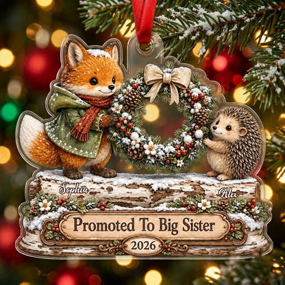 Acrylic ornament with a fox and hedgehog holding a wreath above a wood-style name banner with snowy accents.