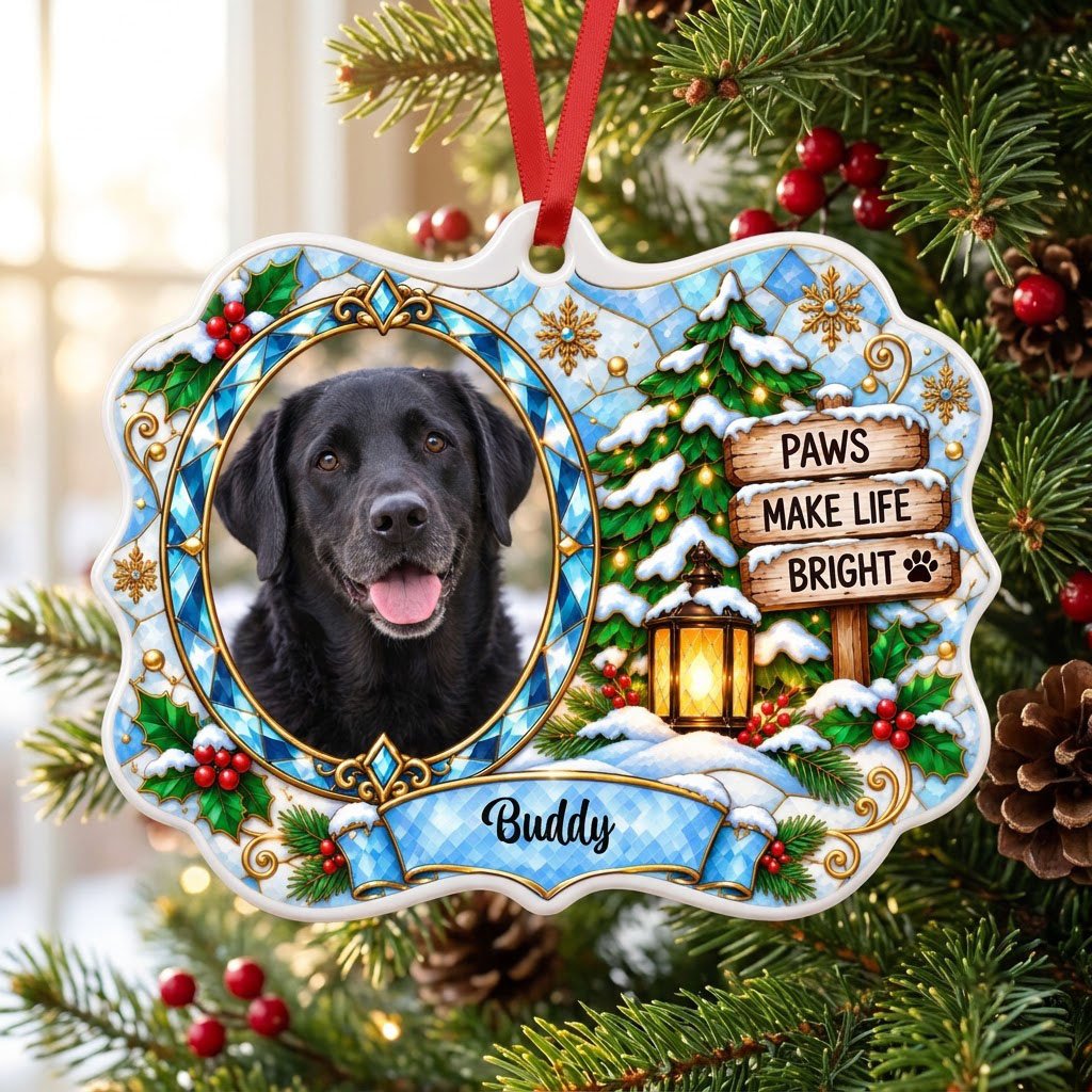 Scalloped ceramic medallion ornament with dog photo, blue stained glass frame, lantern, and Christmas tree in snow.