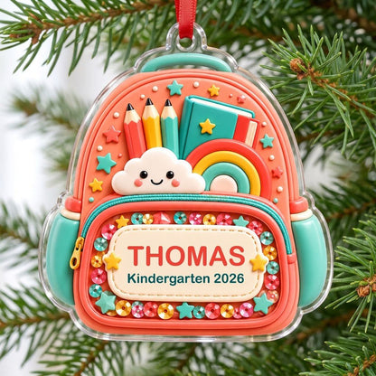 Coral backpack acrylic ornament with pencils, rainbow, smiling cloud, and 'THOMAS' Kindergarten 2026.
