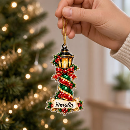 Acrylic ornament with green gift box and smiling elf, jeweled spiral columns, holly, and a name banner.