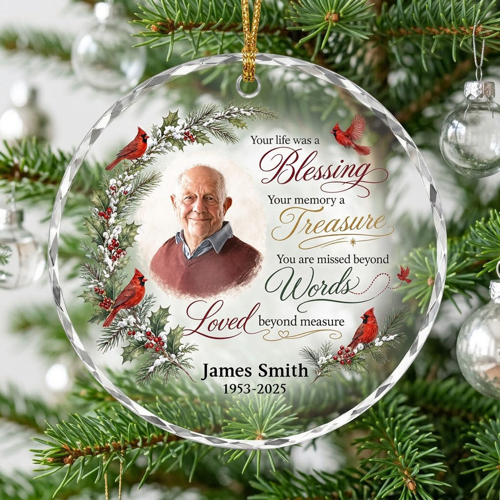 Round glass ornament with memorial quote, four red cardinals, pine and holly greenery, and a center photo portrait.