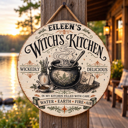 Round wooden hanging sign with a bubbling cauldron, herbs, spellbook, stars and the words Witch's Kitchen.