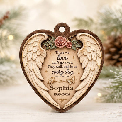 Heart-shaped wood ornament with angel wings, pink roses, butterflies, and a memorial quote with name and dates.