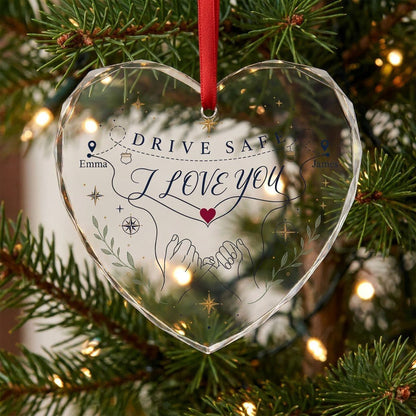 Heart glass ornament showing pinky promise hands, map pins, compass roses, green sprigs, and DRIVE SAFE and I LOVE YOU.