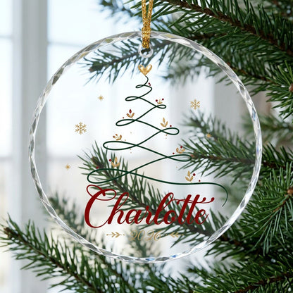 Clear round glass ornament with a looping green line Christmas tree topped by a small gold heart, name and year.
