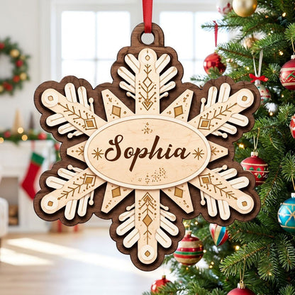 Layered wood snowflake ornament with geometric engravings and a central oval name plate for a custom name.