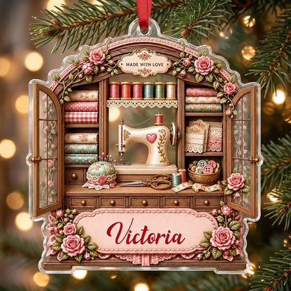 Acrylic ornament shaped like a sewing cabinet with roses, sewing machine, scissors and a pink name banner.
