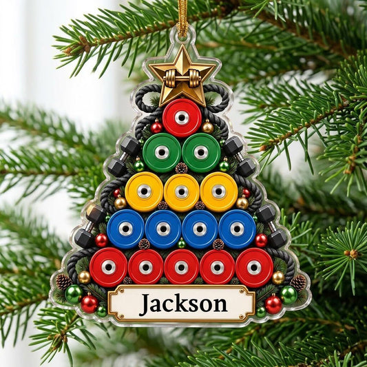 Acrylic tree ornament of colorful weight plates with gold star, side dumbbells, pine sprigs, and a name banner.