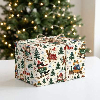 Wrapping paper featuring cartoon cats in winter gear skiing with pine trees, cabins, crossed skis and snowflakes.