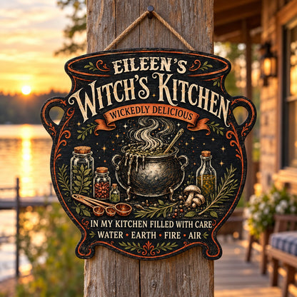 Custom-cut wooden sign shaped like a cauldron with herbs, potion jars, orange scroll and Witch's Kitchen text.