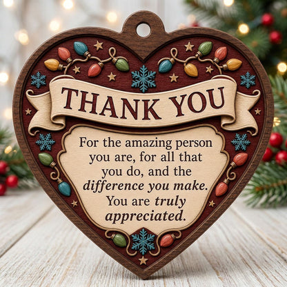 Heart-shaped wood ornament with THANK YOU message, string lights, snowflakes and stars on a burgundy background.
