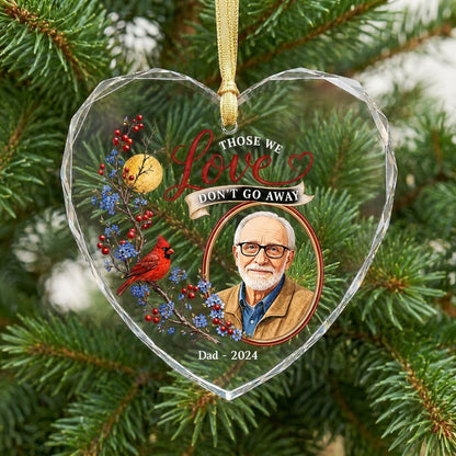 Heart-shaped glass ornament with a red cardinal, golden moon, photo frame and the quote 'THOSE WE Love DON'T GO AWAY'.
