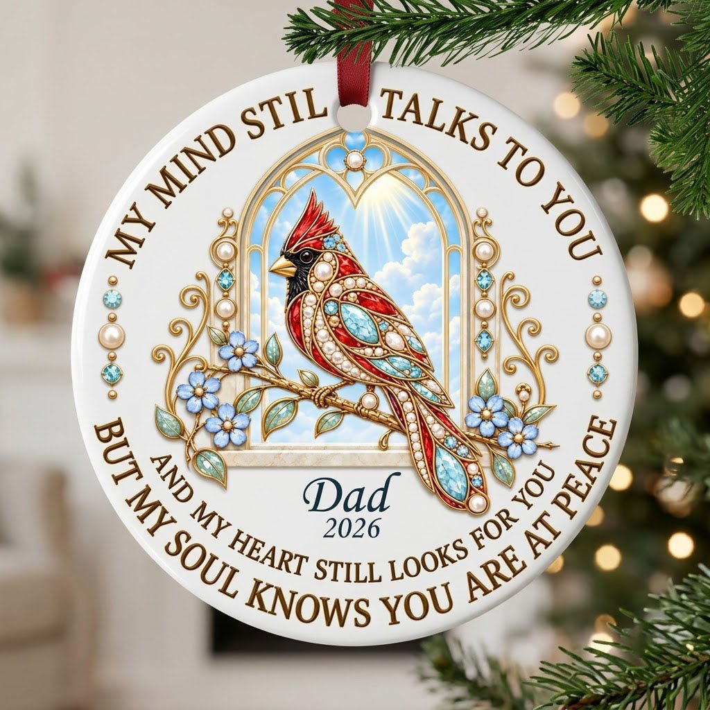 Round ceramic ornament with a red cardinal by a gold arched window, blue flowers, pearls, and a faux marble border.