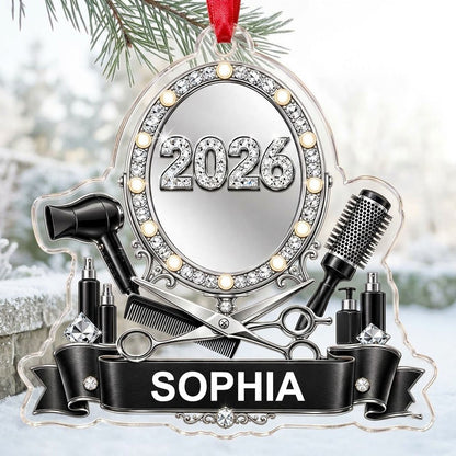 Clear acrylic ornament with a lit vanity mirror and salon tools, featuring SOPHIA and 2026 on a black banner.