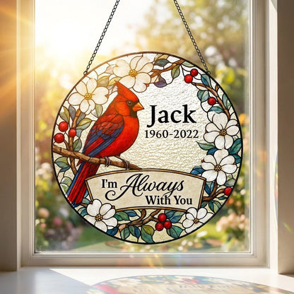 Round stained glass–style suncatcher with a red cardinal on a branch, white flowers, red berries, and a scroll banner.