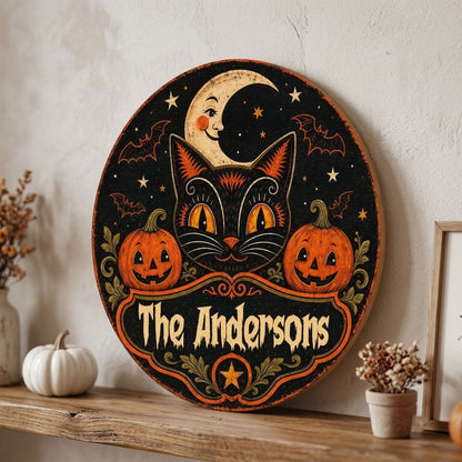 Round wooden sign with vintage black cat face, crescent moon, pumpkins, bats, stars and custom family name.