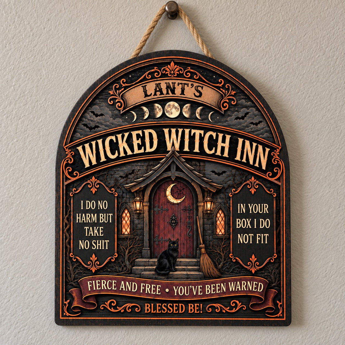 Arch wooden sign with a witch's cottage, bats, moon phases, red crescent door, broom, and a black cat on the steps.