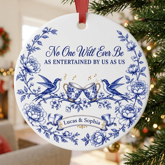 Round ceramic ornament with blue toile border, two birds, clinking floral teacups and gold music notes with two names.