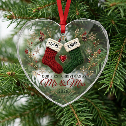 Heart-shaped glass ornament with red and green stockings hanging from gold rings and a red gemstone heart