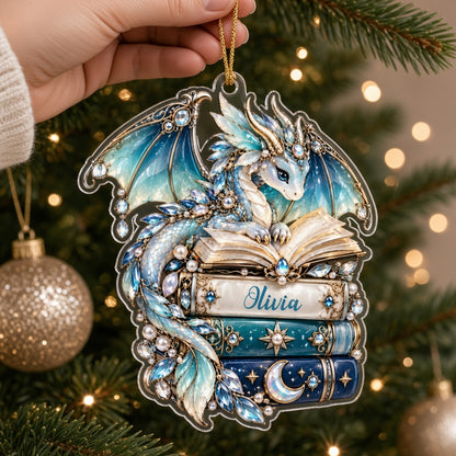 Custom-cut acrylic ornament of a jeweled blue dragon on stacked books with a red ribbon and a personalized name.