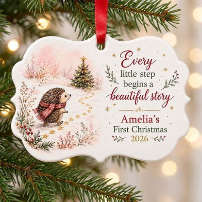 Scalloped ceramic ornament with hedgehog in red plaid scarf walking toward a decorated Christmas tree in the snow.