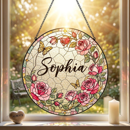 Round stained-glass style suncatcher with pink roses, two yellow butterflies, green leaves, and a decorative patterned b