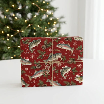 Red Christmas wrapping paper with largemouth bass and rainbow trout, some in Santa hats, pine branches, pinecones, berri