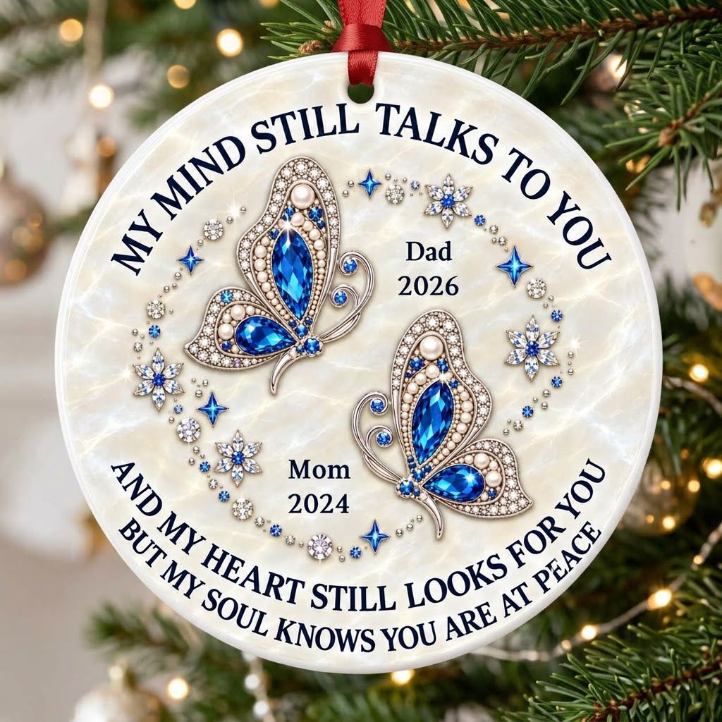 Round ceramic ornament with jeweled blue butterflies, floral rhinestones, and a cream marble background with memorial qu
