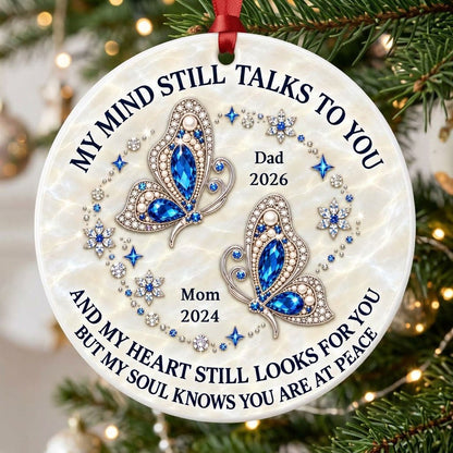 Round ceramic ornament with jeweled blue butterflies, floral rhinestones, and a cream marble background with memorial qu