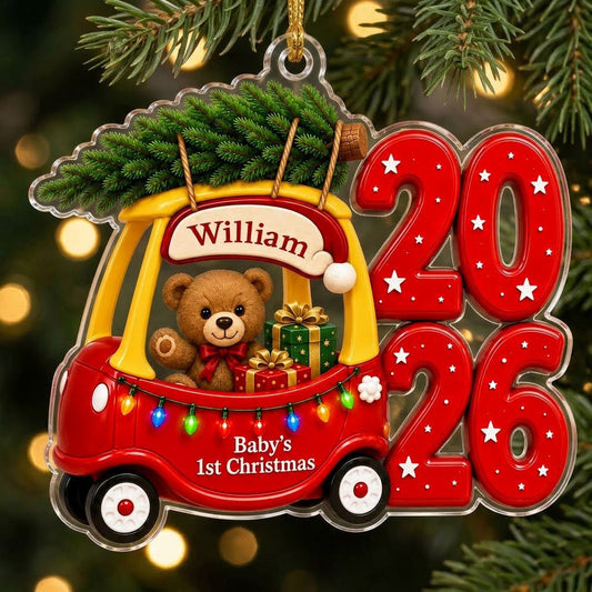 Red toy car with pine tree, teddy bear and gifts, "Baby's 1st Christmas" and 2026 star-pattern numbers on clear acrylic.