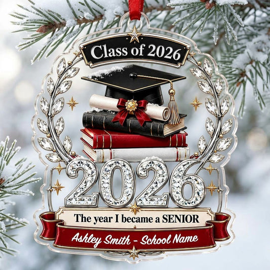 Acrylic ornament shows Class of 2026 text, cap, diploma, jeweled laurel wreath and banners personalized with name and sc