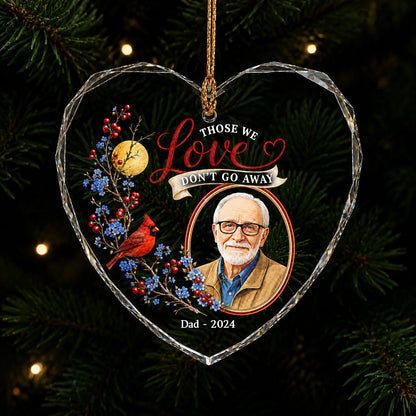 Heart-shaped glass ornament with a red cardinal, golden moon, photo frame and the quote 'THOSE WE Love DON'T GO AWAY'.