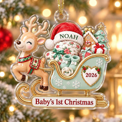 Acrylic ornament of a reindeer pulling a mint-green sleigh with a baby, gifts, and 'Baby's 1st Christmas' text.