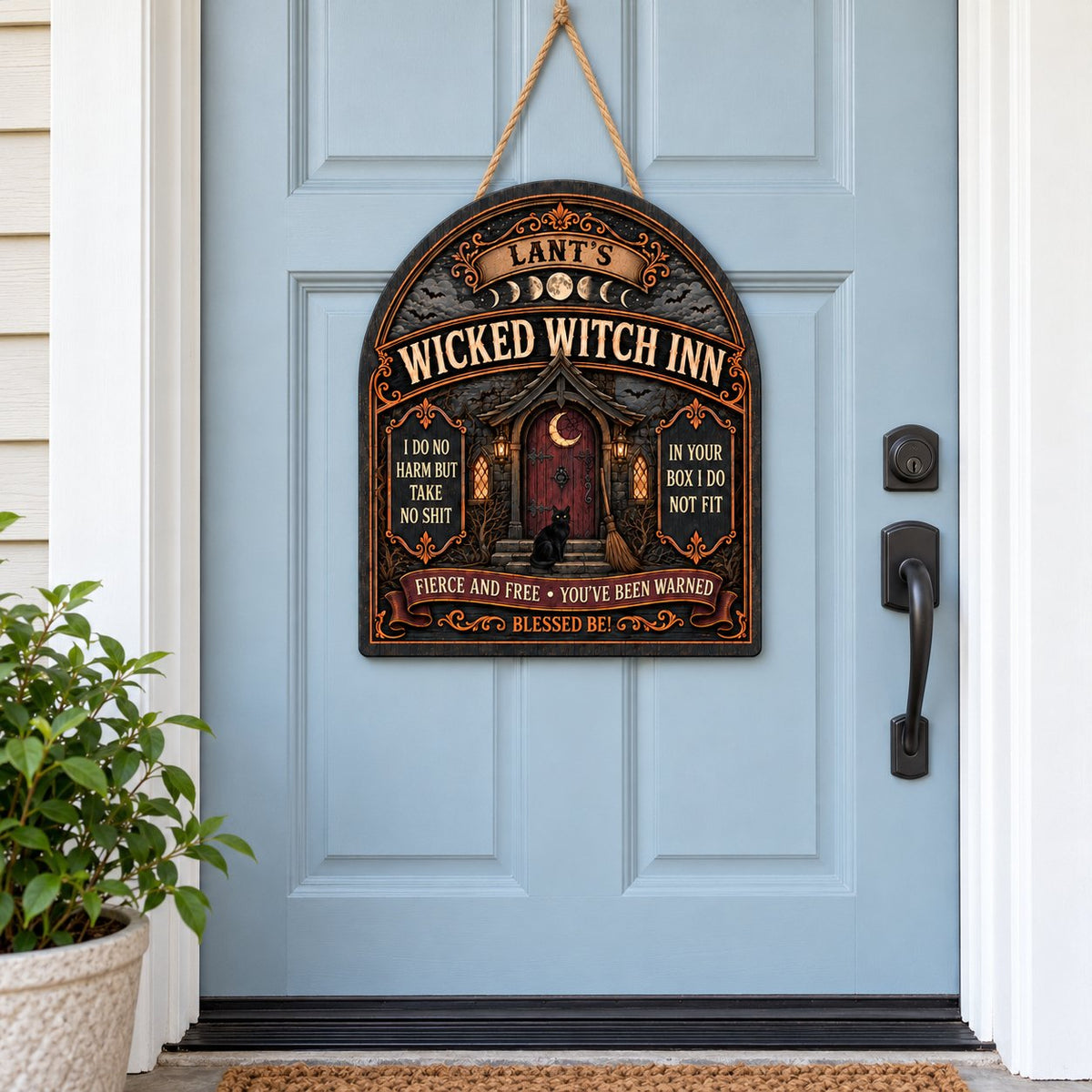 Arch wooden sign with a witch's cottage, bats, moon phases, red crescent door, broom, and a black cat on the steps.