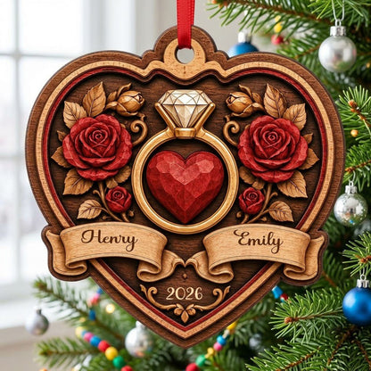 Heart-shaped wood ornament with a gold ring, red heart, red roses, and names Henry and Emily with year 2026.