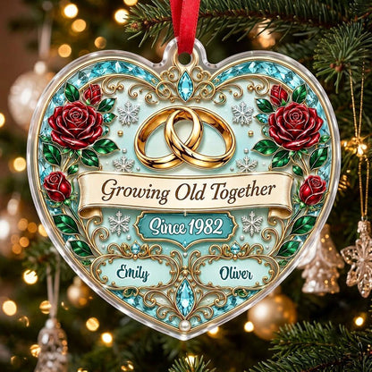 Heart-shaped clear acrylic ornament with golden rings, red roses, “Growing Old Together,” and custom names with a since 