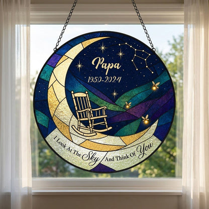Round stained-glass suncatcher with a crescent moon, rocking chair, fireflies and a memorial banner.