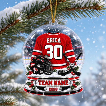 Snow globe acrylic ornament with red and white hockey jersey, black helmet and puck, and a snowy rink backdrop.