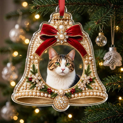 Bell-shaped acrylic ornament with red velvet bow, pearl and gold accents, and a central circular photo frame.