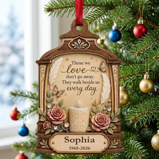 Arched wood-look ornament with lit white candle, two pink roses, butterflies, feathers, and a memorial quote.
