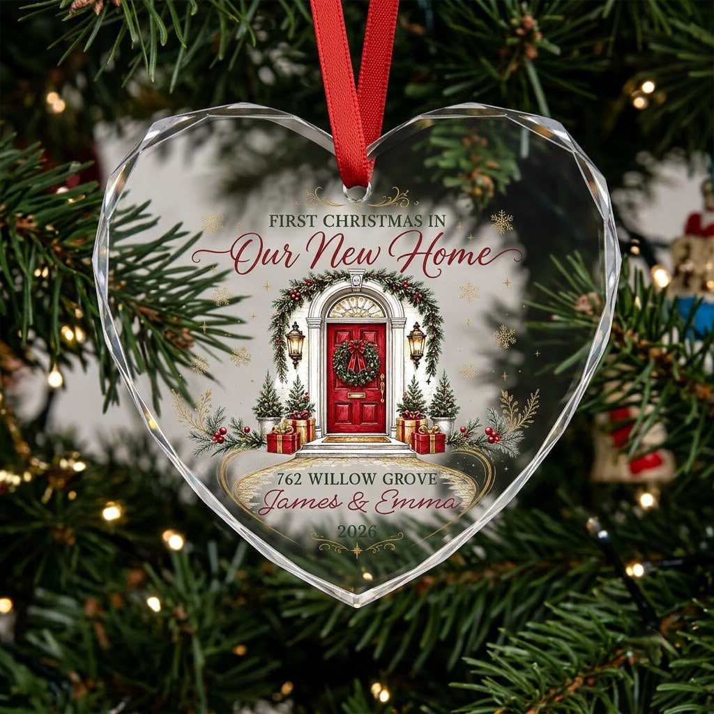 Heart-shaped glass ornament with a red front door, wreath, garland, lanterns, gift boxes, and gold snowflakes.