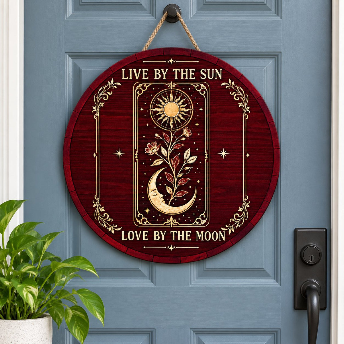 Round wooden sign with tarot-style sun and sleeping moon, floral vine, stars, and the words Live by the Sun, Love by the