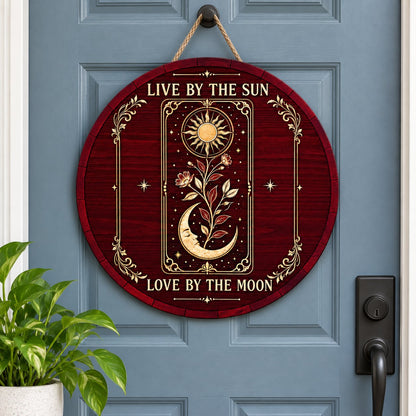 Round wooden sign with tarot-style sun and sleeping moon, floral vine, stars, and the words Live by the Sun, Love by the