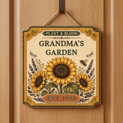 Square bracketed wooden sign with three sunflowers, lavender, a honeybee, and “Plant & Bloom” and “Grandma’s Garden” tex