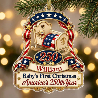 Acrylic ornament with baby crib, teddy bear, patriotic ribbon, and 'Baby's First Christmas', personalized with name and 