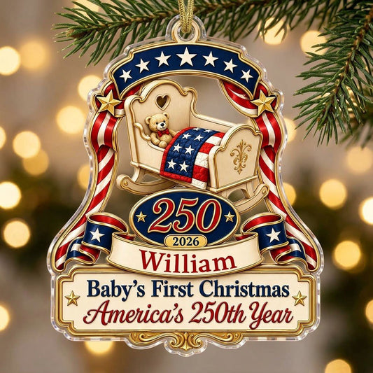 Acrylic ornament with baby crib, teddy bear, patriotic ribbon, and 'Baby's First Christmas', personalized with name and 