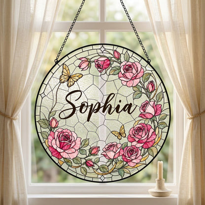 Round stained-glass style suncatcher with pink roses, two yellow butterflies, green leaves, and a decorative patterned b