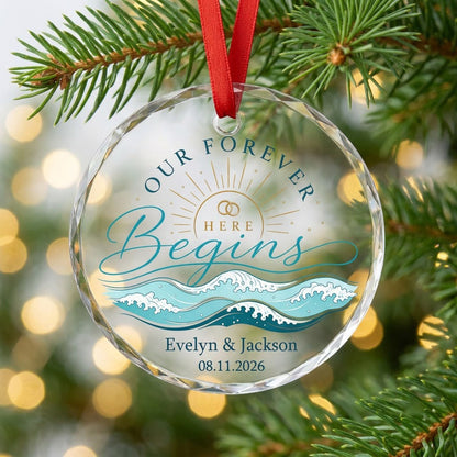 Round glass ornament with gold sun, interlocking rings, teal ocean waves, and 'OUR FOREVER HERE Begins' text.