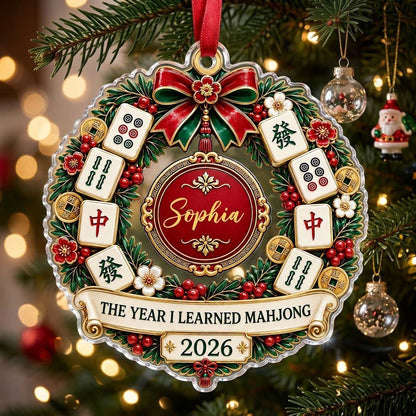 A clear acrylic wreath ornament with Mahjong tiles, red bow, gold coins, and the text THE YEAR I LEARNED MAHJONG.