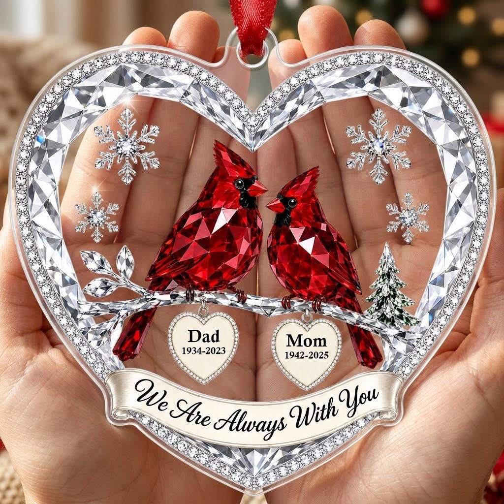 Heart ornament with two red crystal-style cardinals, snowflakes, a ribbon banner, and two dangling name-date heart charm